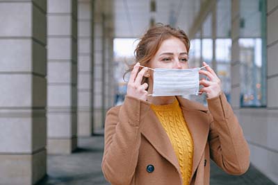 Woman putting on mask